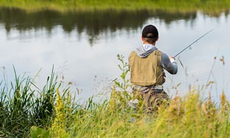 Ein Fischer mit einer Angel am See